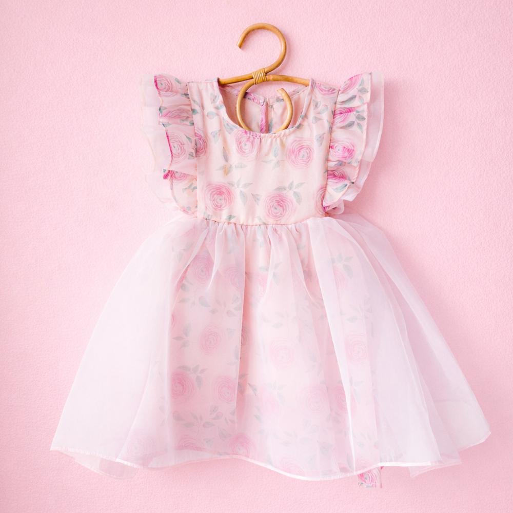 Pink chiffon Rose Sundress Pinny with ruffled sleeves and multi-layer skirt, hanging on a wooden hanger.