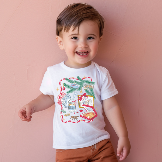 Child wearing a white t-shirt with a colorful graphic and brown shorts against a pink background