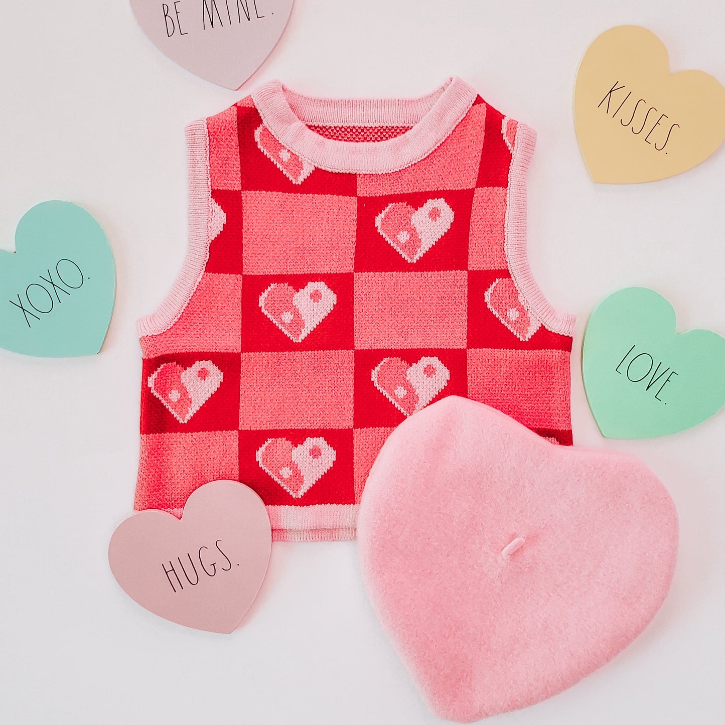 Red checkered baby outfit with heart patterns on a light background
