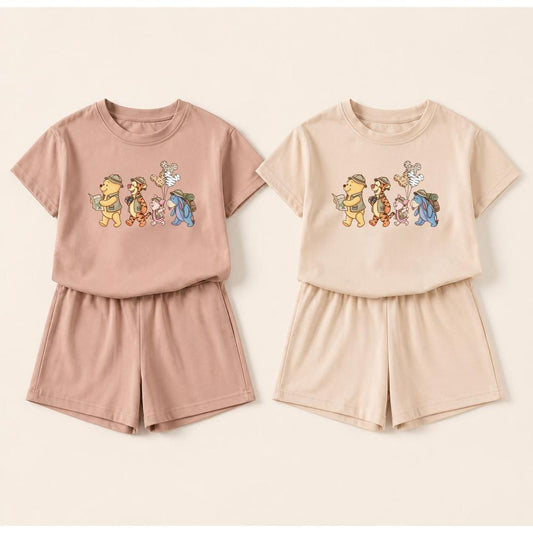 Honey Safari Pals two-piece sets in blush pink and beige, featuring Winnie the Pooh characters on short-sleeve tops and matching shorts.