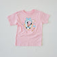 Pink kids' t-shirt with "Miss Mouse in Paris" design featuring The Mouse in sunglasses, Eiffel Tower, and macarons.