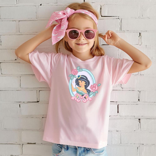 Young girl in a light pink t-shirt featuring a Princess Jasmine graphic with roses, wearing pink sunglasses and a matching headband.