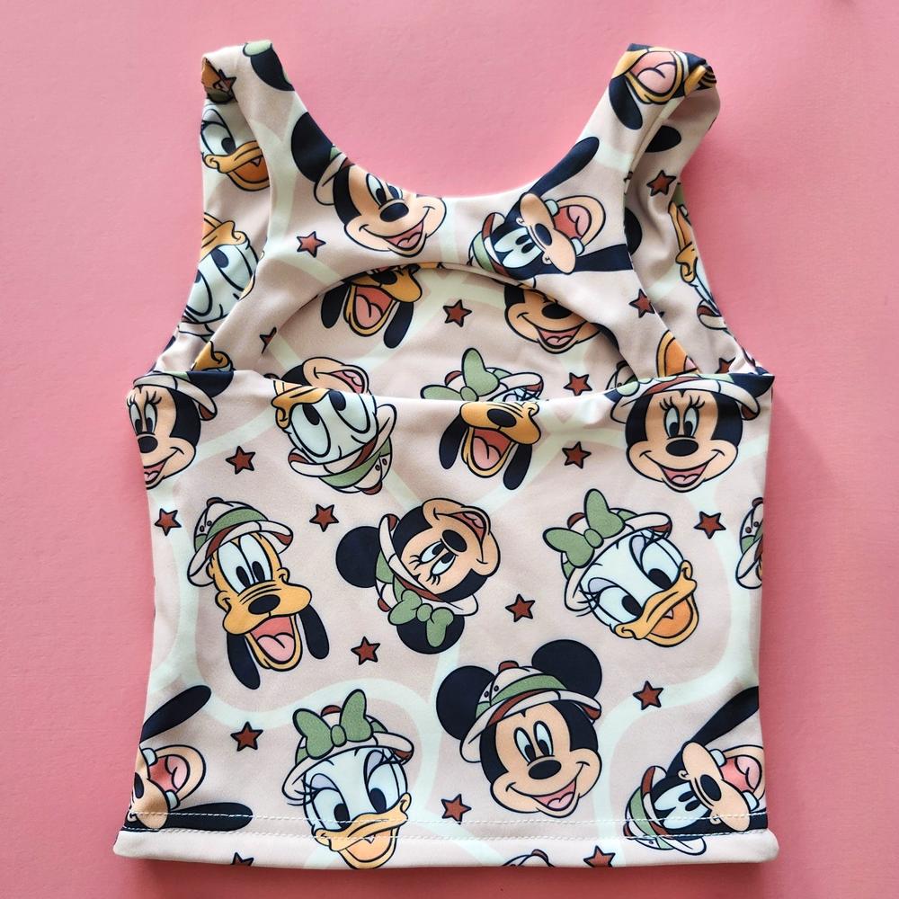 Kids' pink activewear top with The, The, Ducky, Daisy, and Doggy safari print and back cutout.