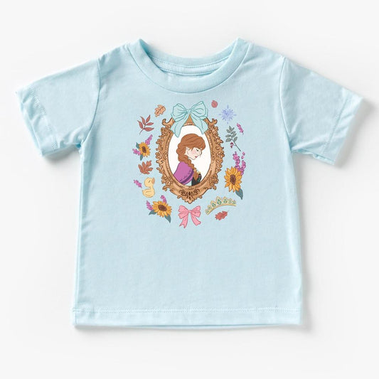 Light blue Anna Kids & Adult T-shirt with a framed Anna character design, surrounded by colorful flowers and bows.