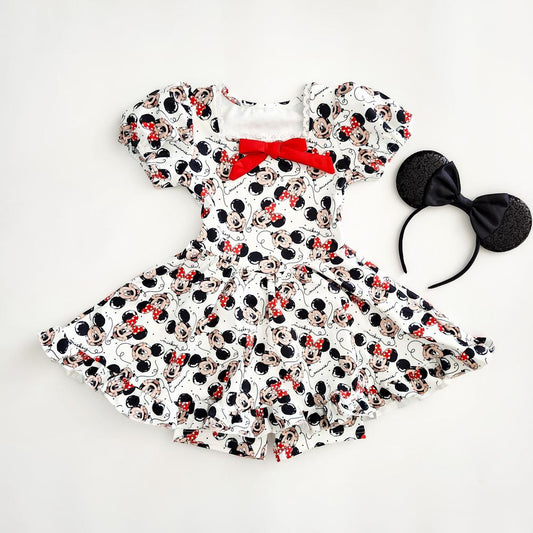White activewear dress and detached biker shorts with The Mouse print, red bow, and matching The ears.