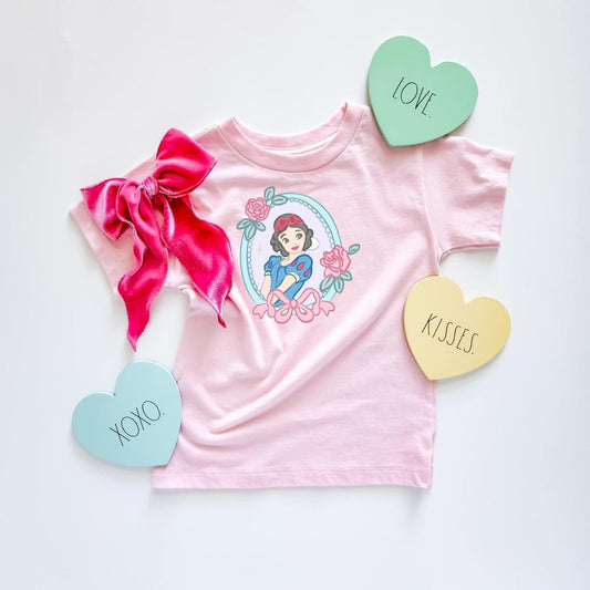 Pink Faire Maiden T-shirt with Snow White graphic, surrounded by roses and a bow. Includes a pink velvet bow and heart-shaped "Love," "Kisses," and "XOXO" signs.
