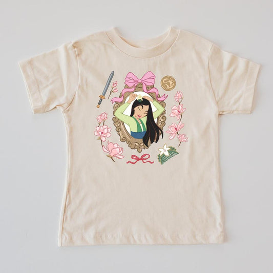 Fearless Warrior kids' cream t-shirt with Mulan character design, pink bows, sword, coin, and cherry blossoms.