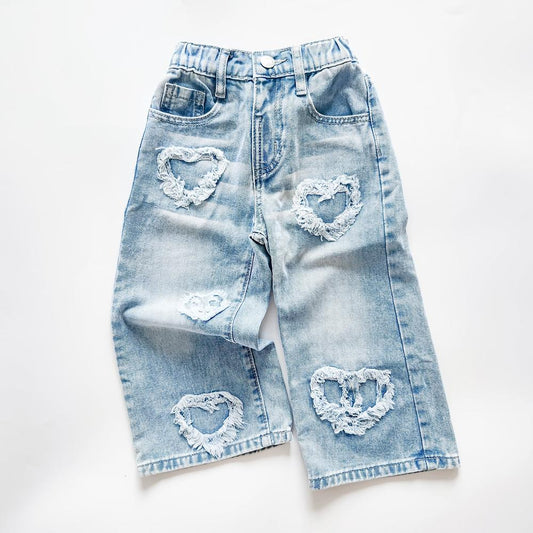 Light wash denim jeans with frayed sweetheart cutouts and elastic waist.