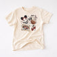 Cream t-shirt with a "Girly Pirate Mouse" design featuring The ears, a pirate ship, framed pirate mouse, and cherries.