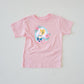 Pink short-sleeve t-shirt with a graphic of Cinderella in a blue dress, framed by pink roses and a bow.