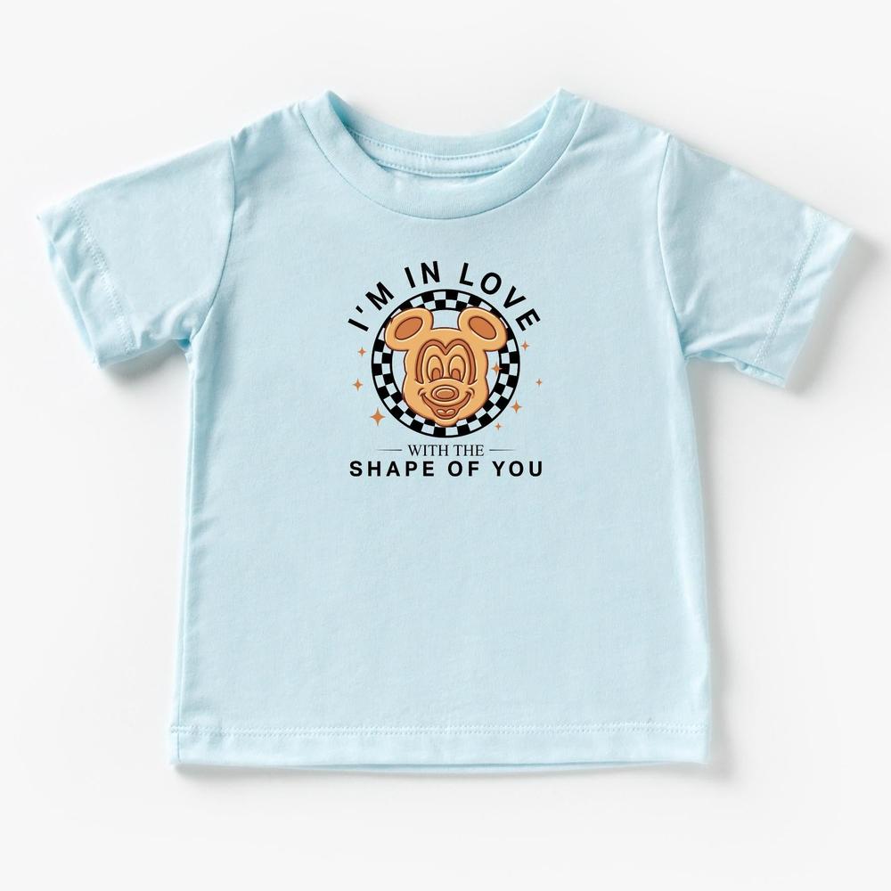 Light blue kids' t-shirt with "I'm In Love With The Shape Of You" text and The Mouse head on a checkered background.