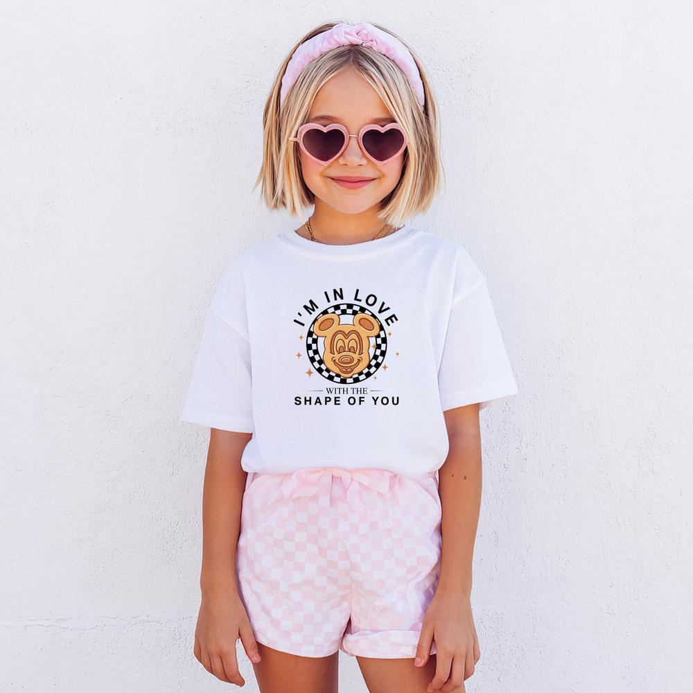 White kids t-shirt with "I'm In Love With The Shape Of You" text and a checkered bear graphic.