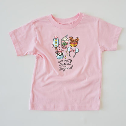 Pink kids' t-shirt with "Infinity Snacks and Beyond" text and cartoon snacks like a rocket, boba, and The-shaped treats.
