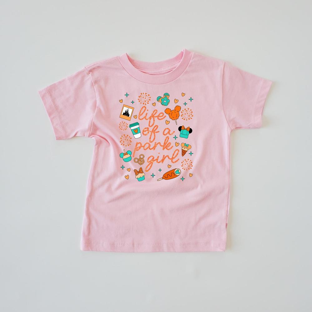 Pink short-sleeve t-shirt with "Life of a Park Girl" text and colorful park-themed icons.