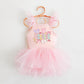 Pink ballerina dress with "Magical" graphic, The ears, wand, and bunnies, featuring ruffled tulle sleeves and skirt.