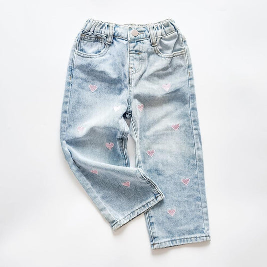 Girls' light wash denim jeans with pink heart embroidery and elastic waist.