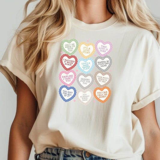 Cream t-shirt with colorful conversation hearts featuring Taylor Swift lyrics and Valentine's Day phrases.