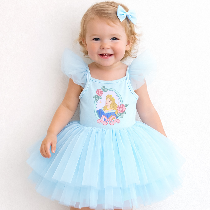 Child wearing a light blue dress with a fairy design on a white background