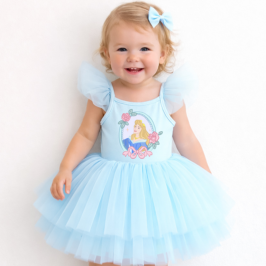 Child wearing a light blue dress with a fairy design on a white background