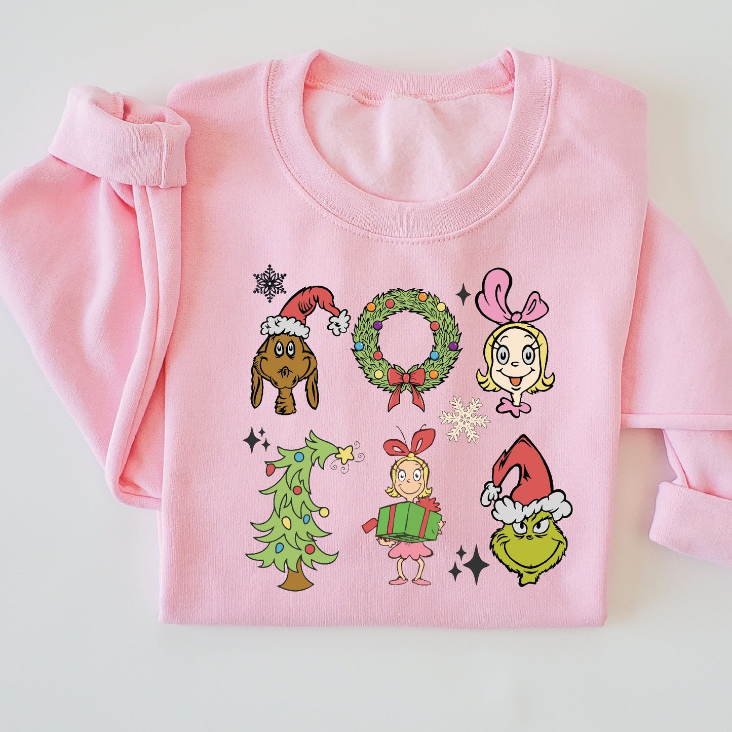 Pink sweatshirt with Christmas-themed cartoon characters on a white background