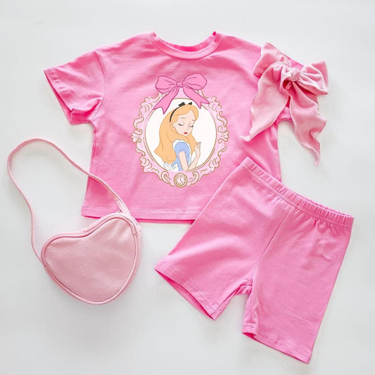 Pink cotton Wonderland Biker Set with Alice graphic tee, biker shorts, heart purse, and matching bow.