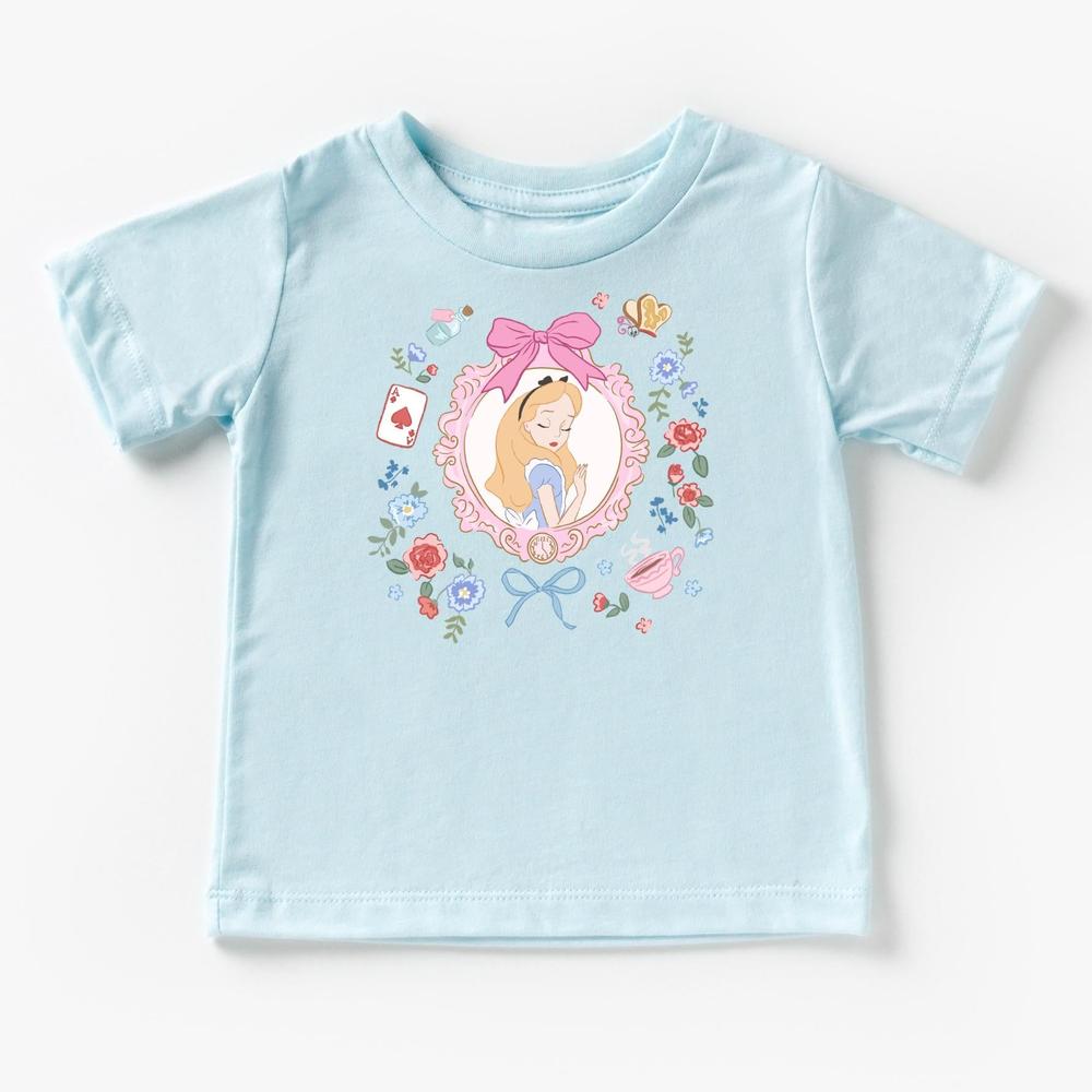 Light blue infant t-shirt with Alice in Wonderland character design framed by flowers, bow, and playing card.
