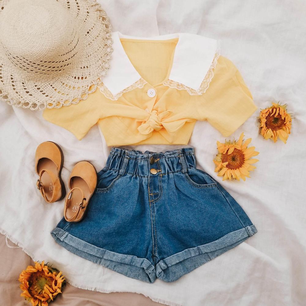 Girls' yellow blouse with white collar, denim shorts, straw hat, sandals and sunflowers